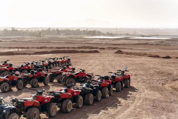 Large column of ATVs and buggies stands in the middle of a sandy desert. Ready for fun in the desert